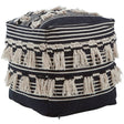 A black and white shaggy pouffe featuring a geometric pattern with alternating stripes and tassels along the edges, providing a textured and stylish accent for home decor