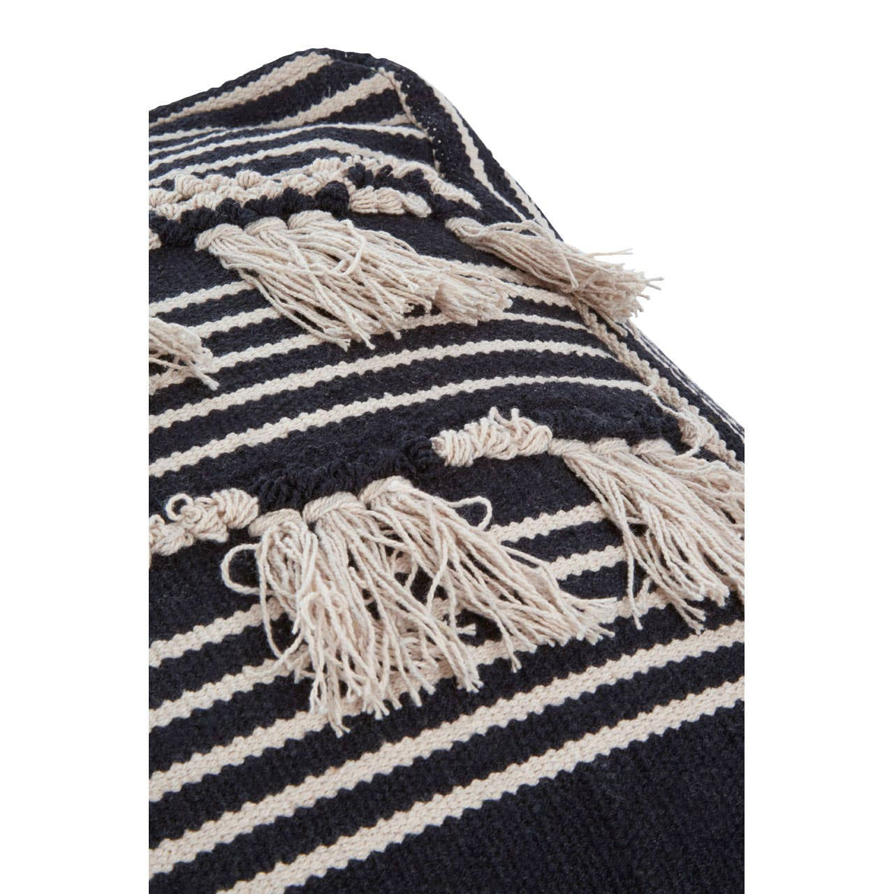 Close-up view of a black and white shaggy pouffe featuring a textured surface with alternating stripes and tassels, showcasing a cozy and stylish design suitable for home decor