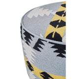 Round footstool featuring a colorful Kilim-style fabric with geometric patterns in shades of blue, yellow, and black, supported by sturdy mango wood legs. The design showcases a textured surface and a contemporary aesthetic suitable for home decor