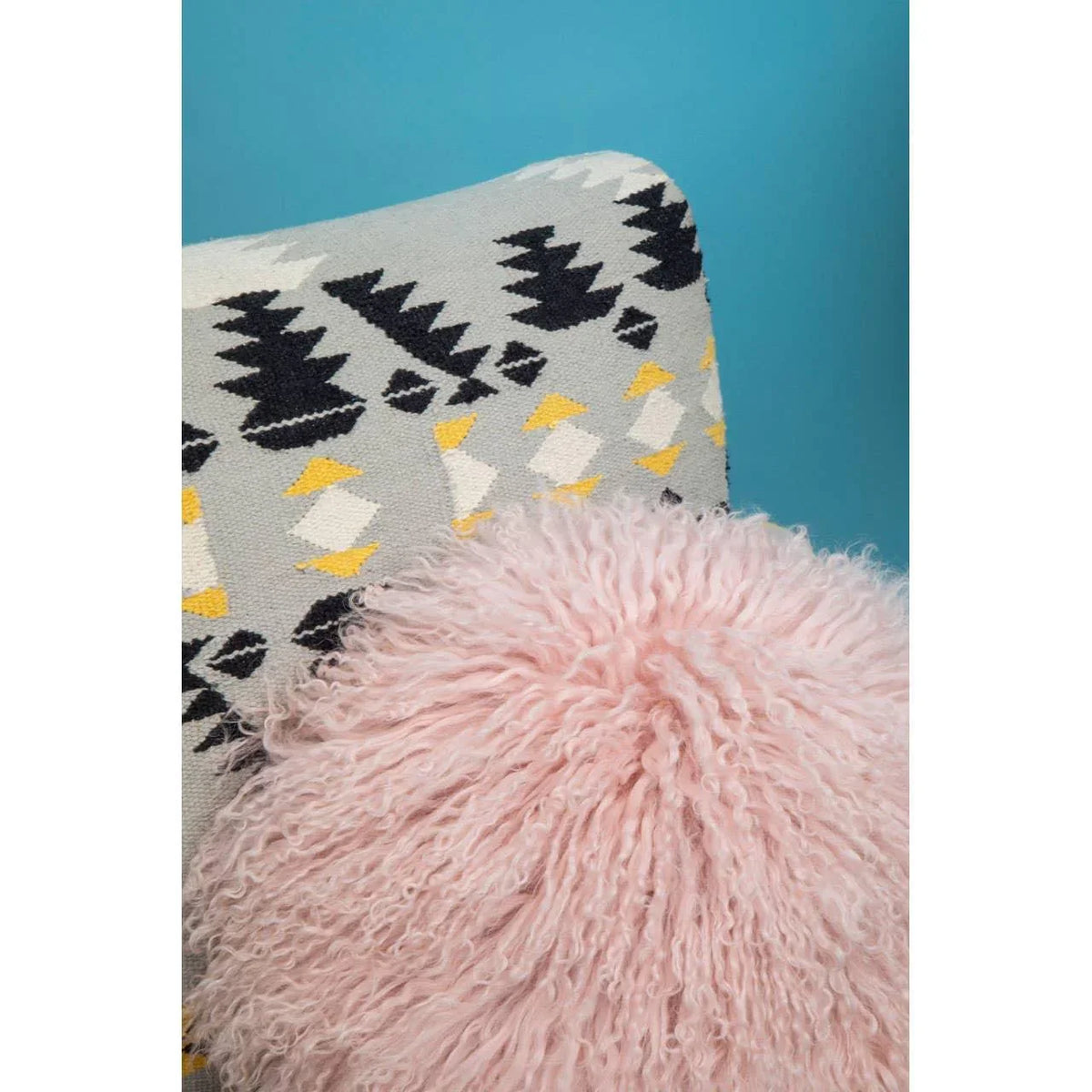Patterned accent chair with geometric upholstery and round pink fluffy cushion