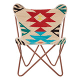 A multicolour butterfly chair featuring a patterned fabric with geometric shapes in red, turquoise, and black on a cream background, supported by a sturdy metal frame with a warm brown finish. The chair's unique design includes rounded top edges and a minimalist structure, making it a stylish addition to any home decor