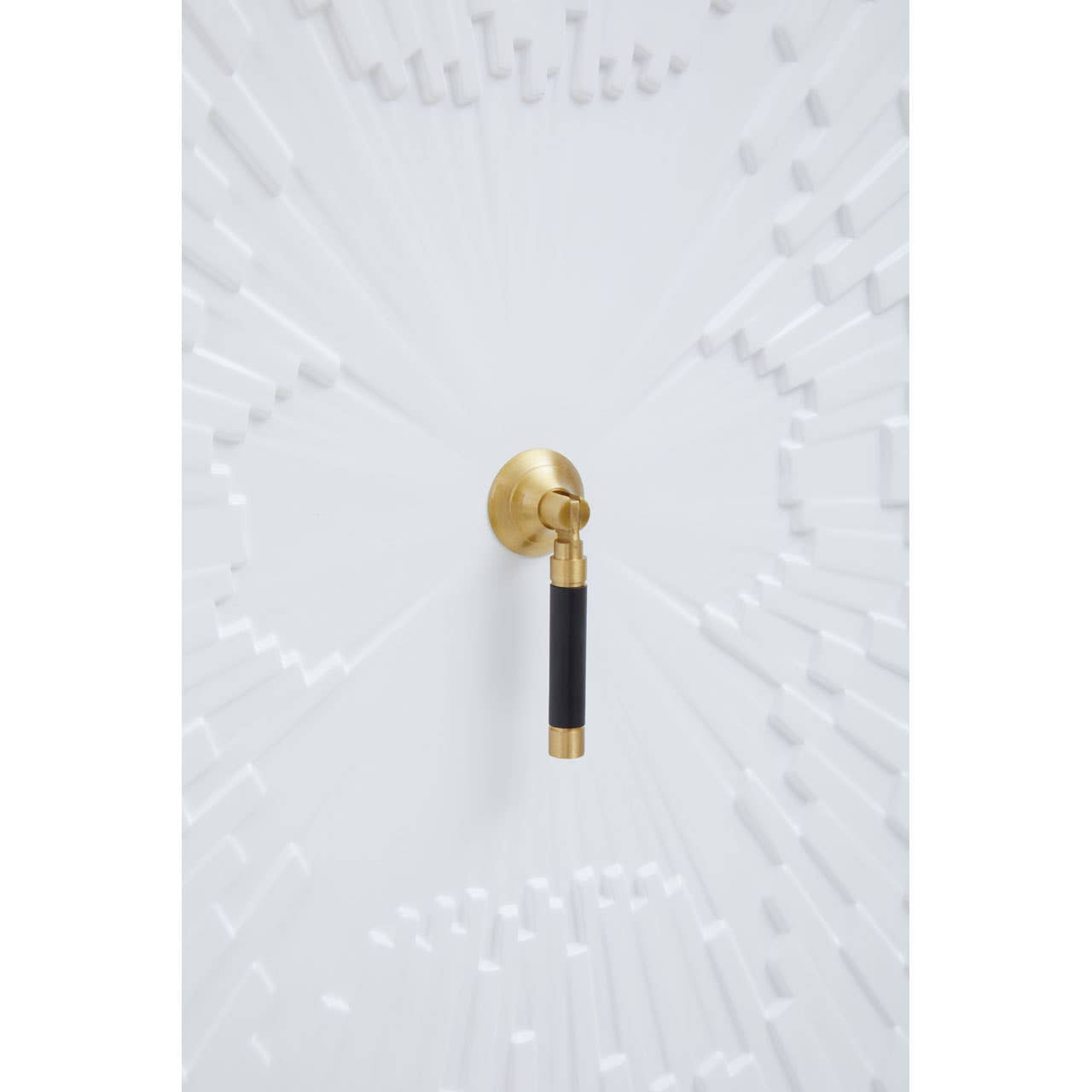 Close-up of a gold and black cabinet handle on a white cabinet door, showcasing a sleek and modern design. The handle features a round gold knob with a black cylindrical grip, set against a textured white surface