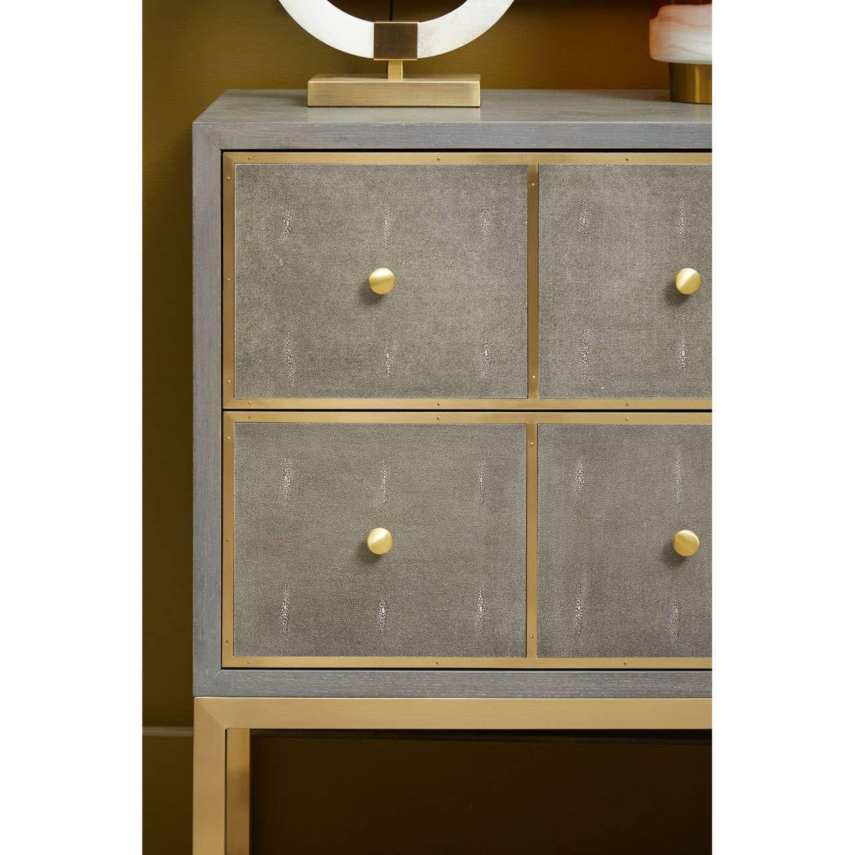 Grey and gold sideboard with four textured drawers and brass knobs
