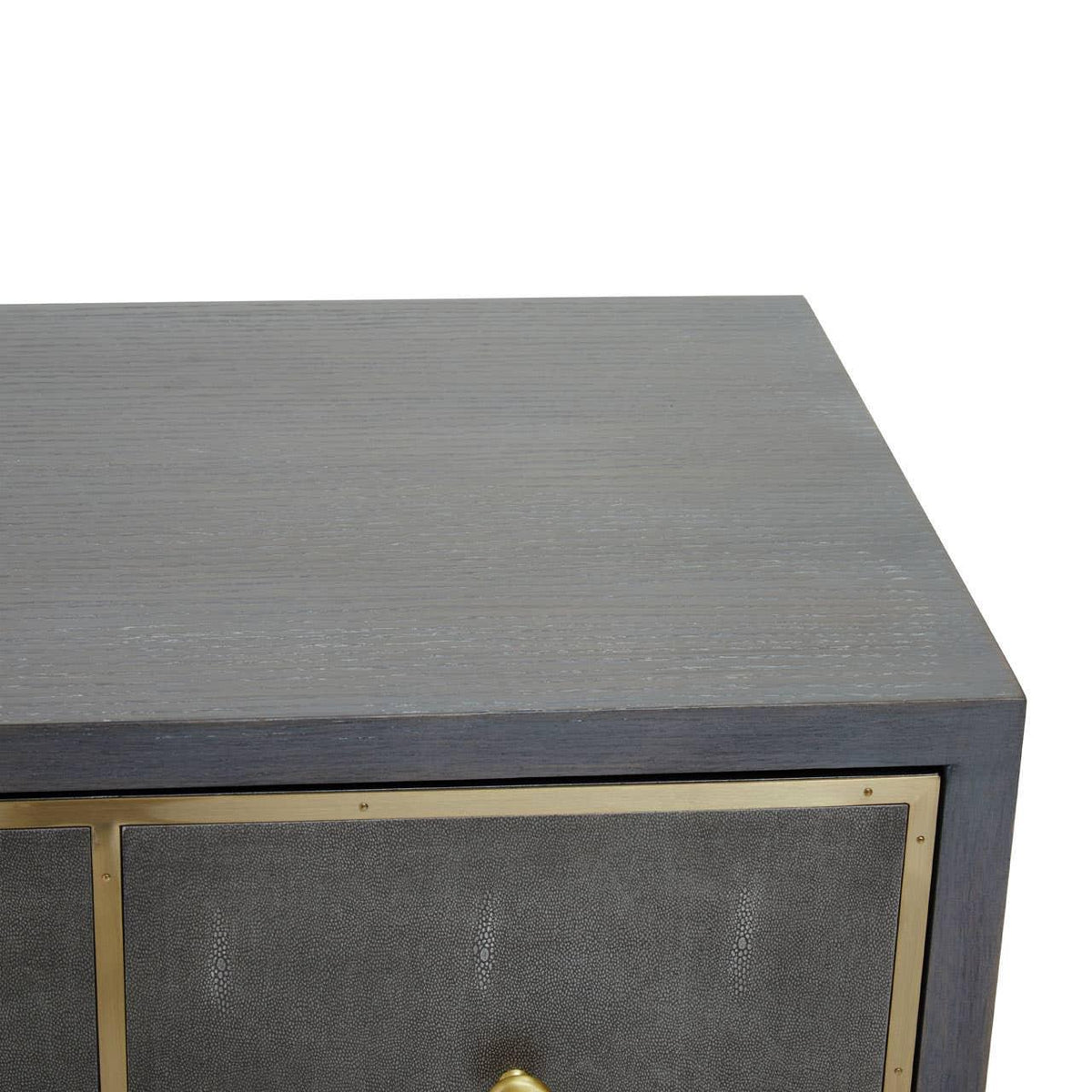 Grey wood sideboard with brass trim and textured drawer front, close-up corner view