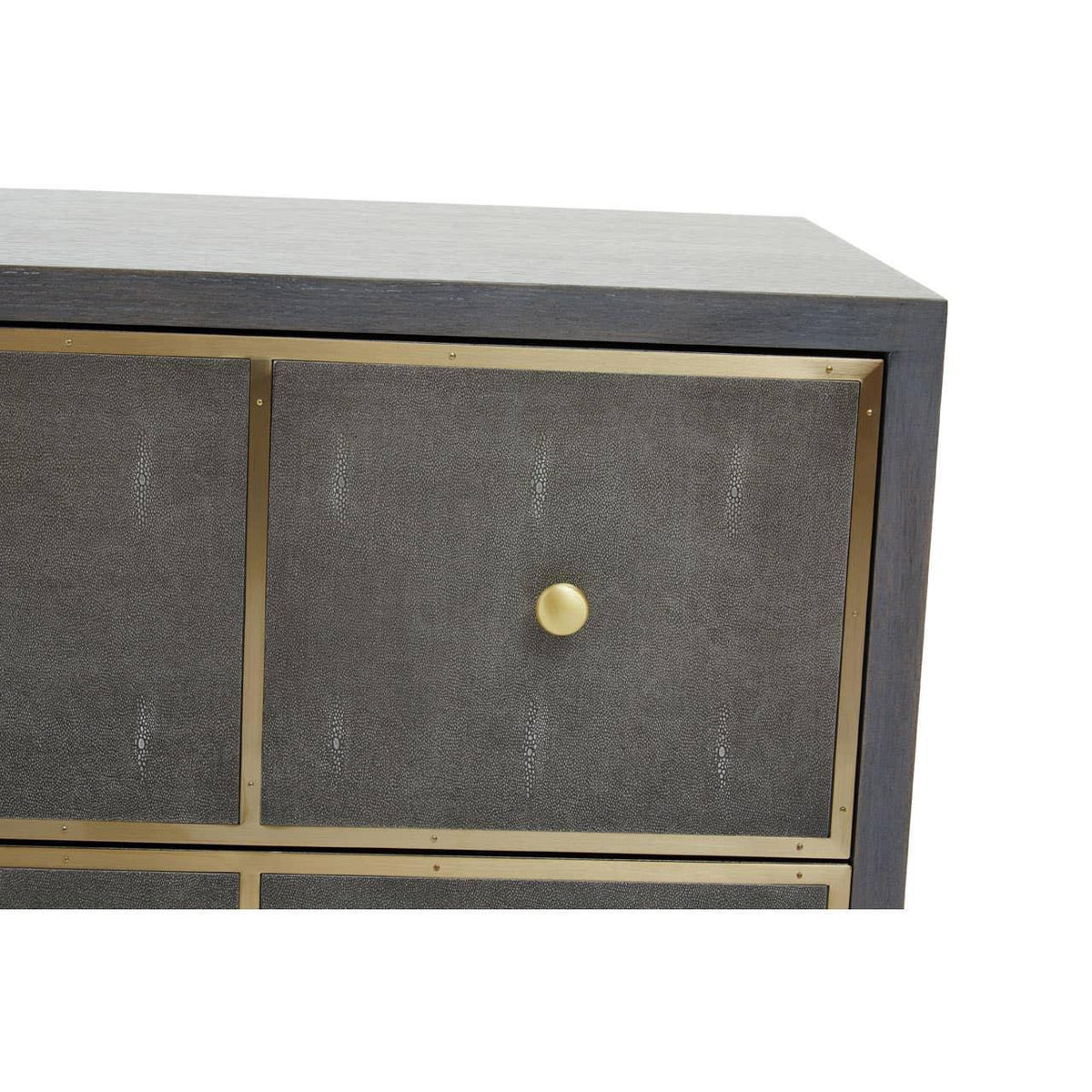 Closeup of chest of drawers with textured grey panel, gold knob and brass trim