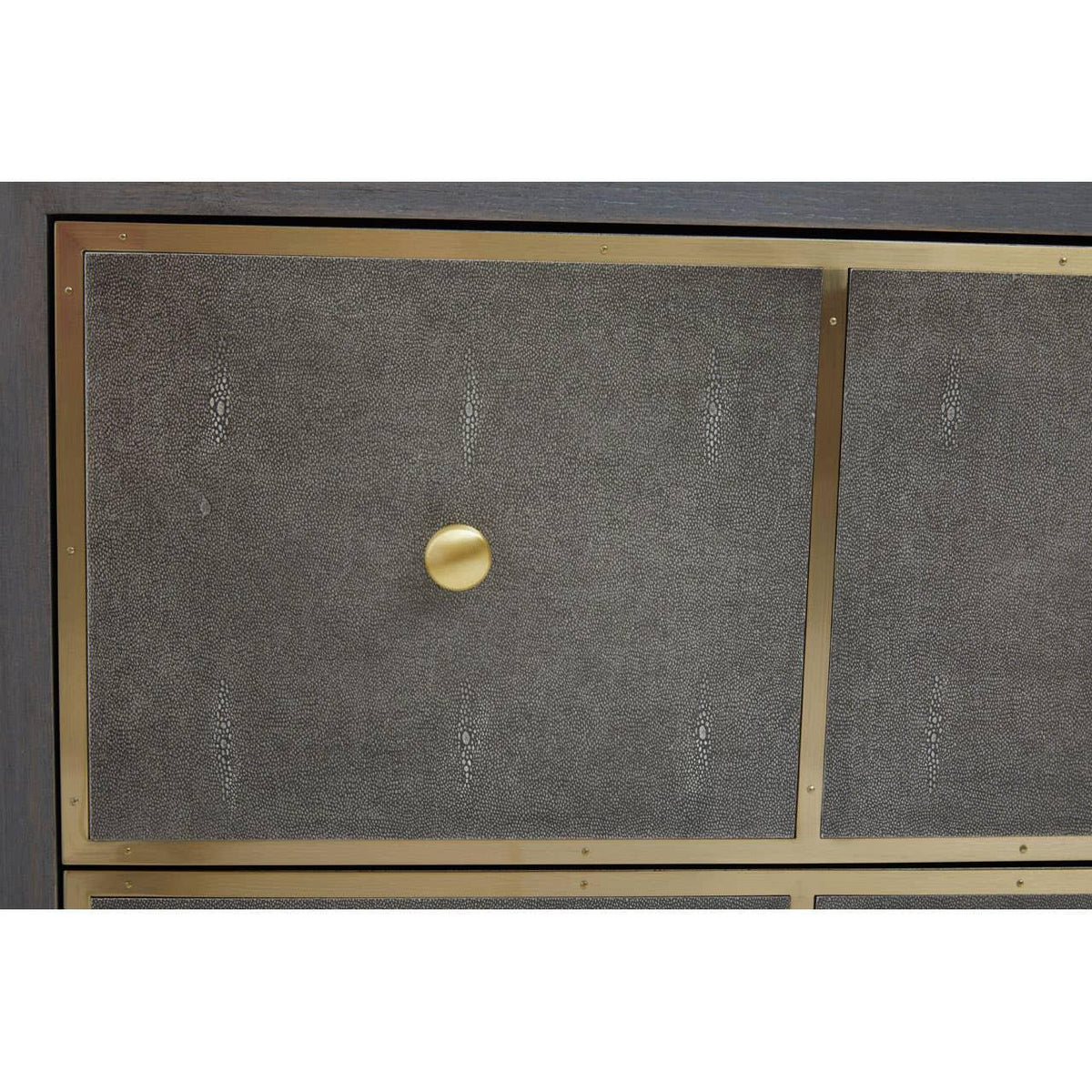Close-up of textured dresser drawer with gold metal frame and round brass handle