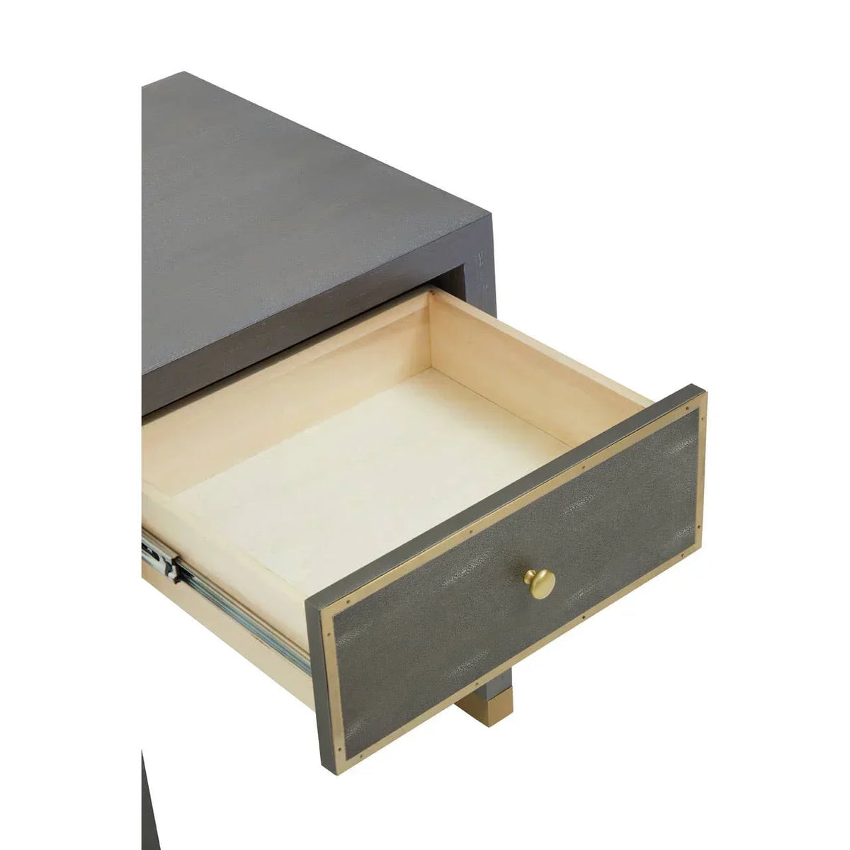 Closeup of modern bedside table with open drawer, textured grey front and gold handle
