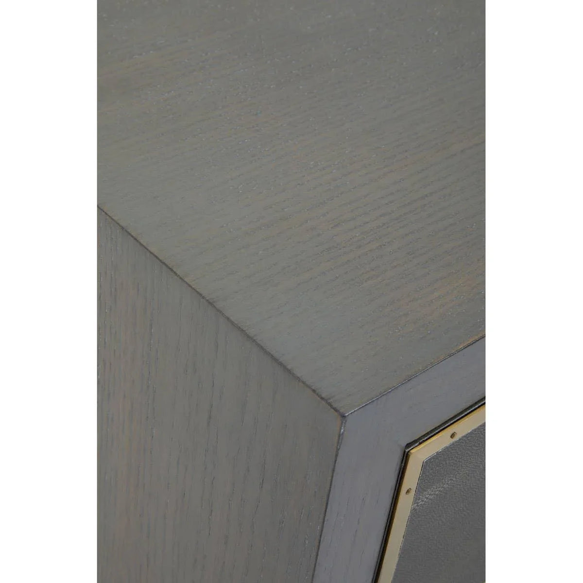 Close view of grey wood cabinet corner with brass trim detail
