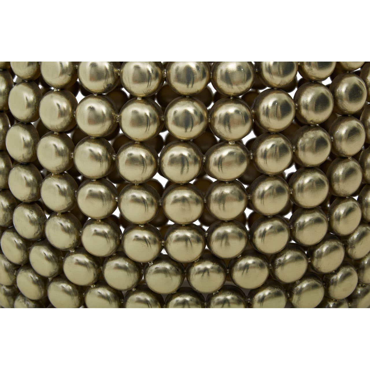 Close-up view of a gold finish stool and side table featuring a textured surface made up of small, round metallic beads arranged in a pattern. The overall design is sleek and modern, showcasing a shiny gold color that reflects light