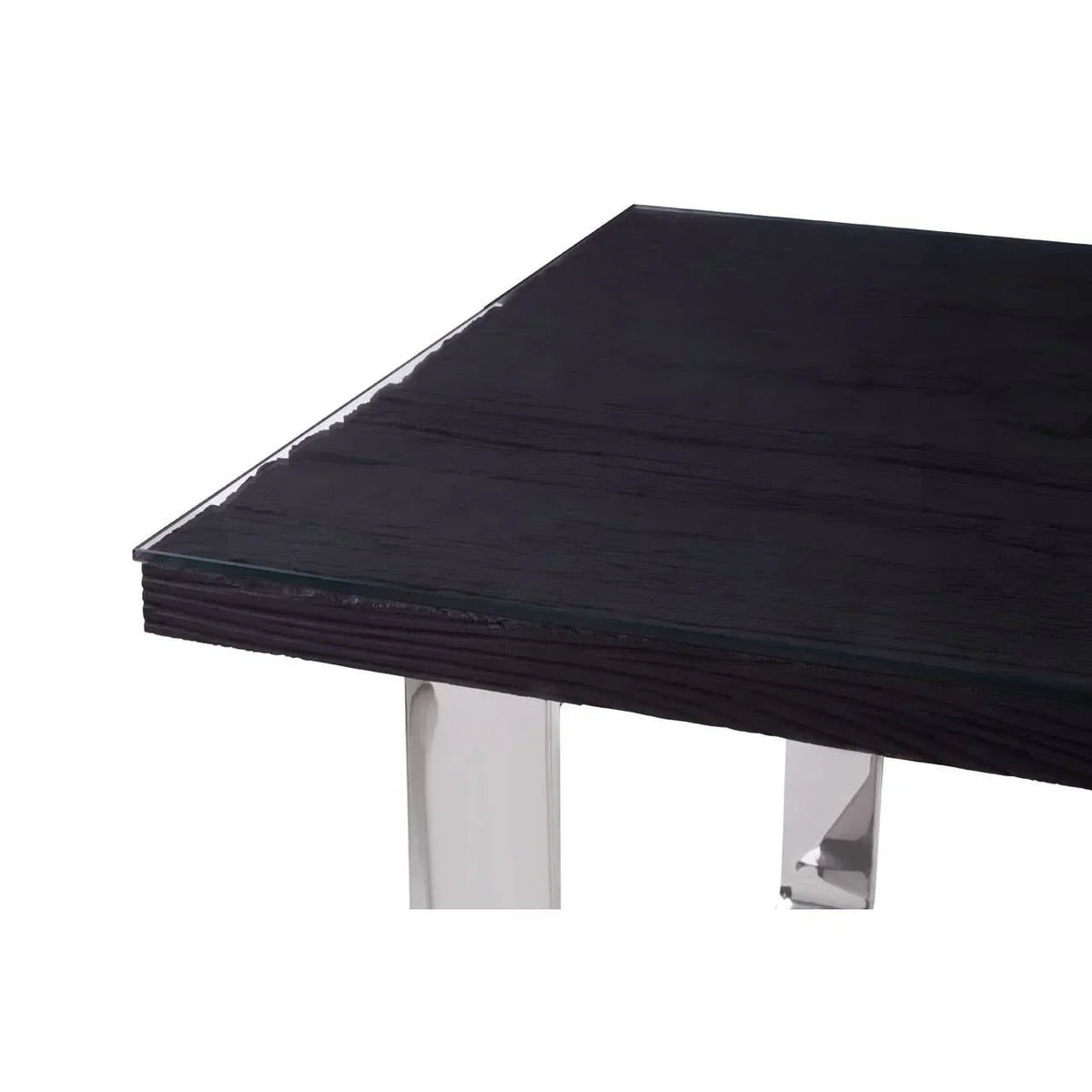 Closeup of dining table with dark wood top, glass overlay, and chrome metal legs