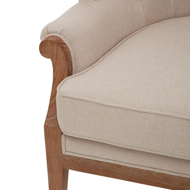 Beige fabric armchair with wooden frame and tufted backrest, corner closeup view