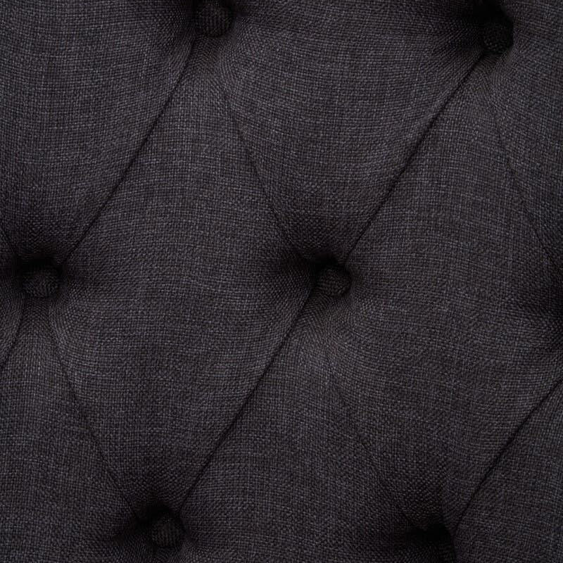 Dark grey upholstered sofa with deep button tufting fabric detail close-up