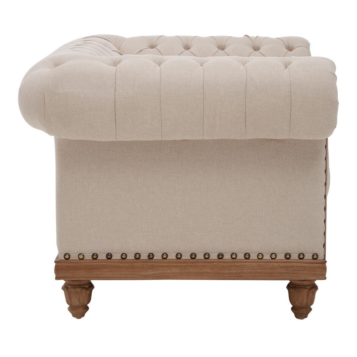 Beige fabric sofa with deep button tufting and wooden legs side view
