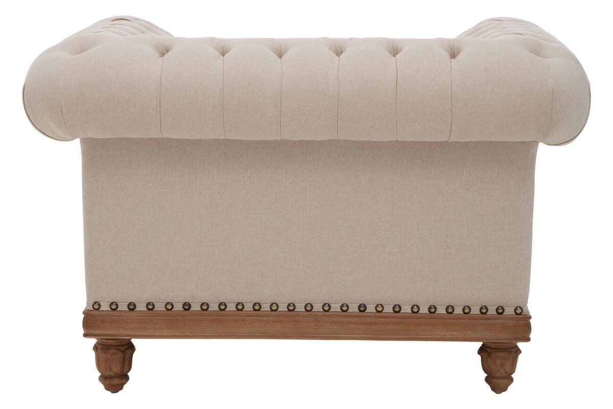 Beige tufted fabric sofa back with wooden legs and stud trim detail