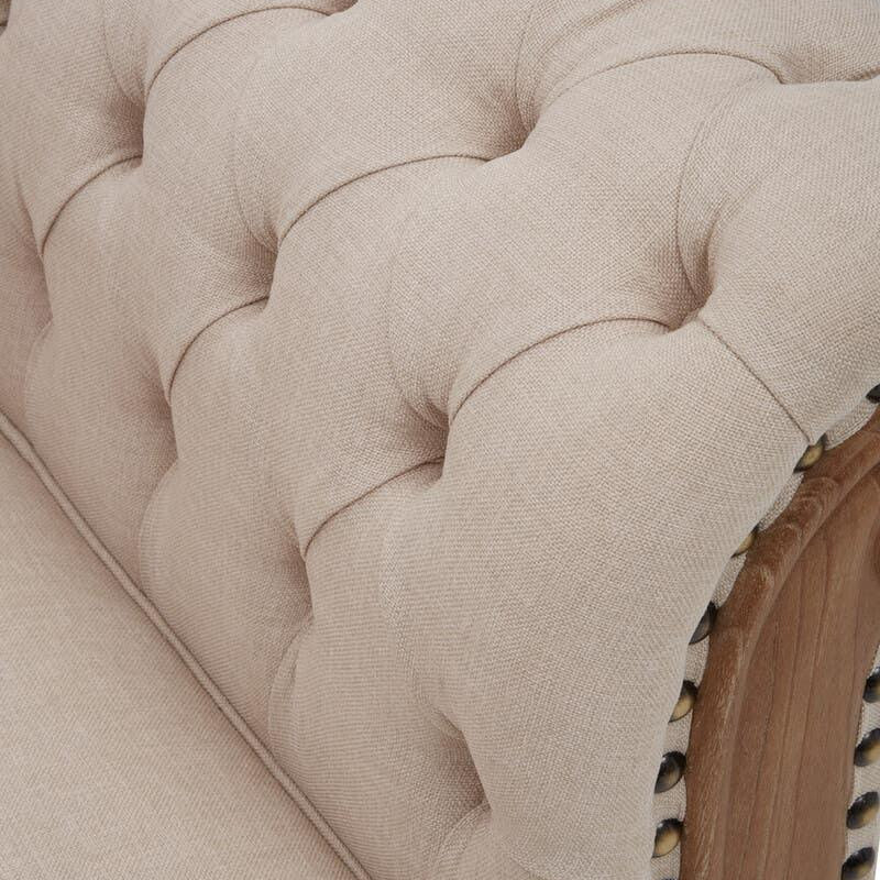 Beige fabric sofa arm with deep button tufting and wooden trim detail