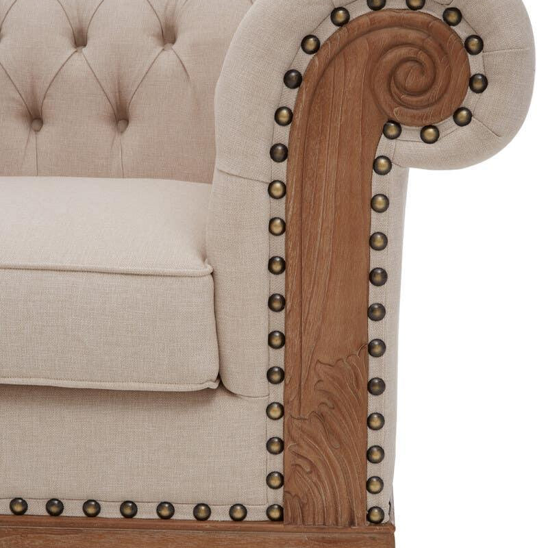 Beige fabric sofa with deep button tufting and carved wood scroll armrest detail