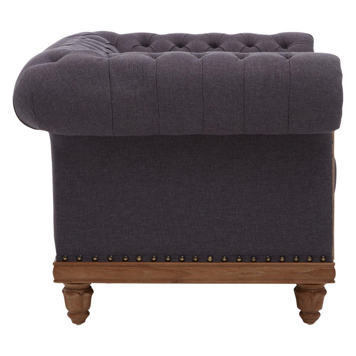 Dark grey fabric Chesterfield sofa side view with button tufting and wooden legs
