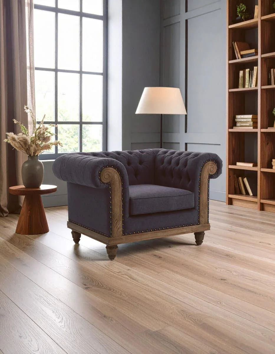 Navy blue velvet armchair with wooden frame and button tufting in a modern living room