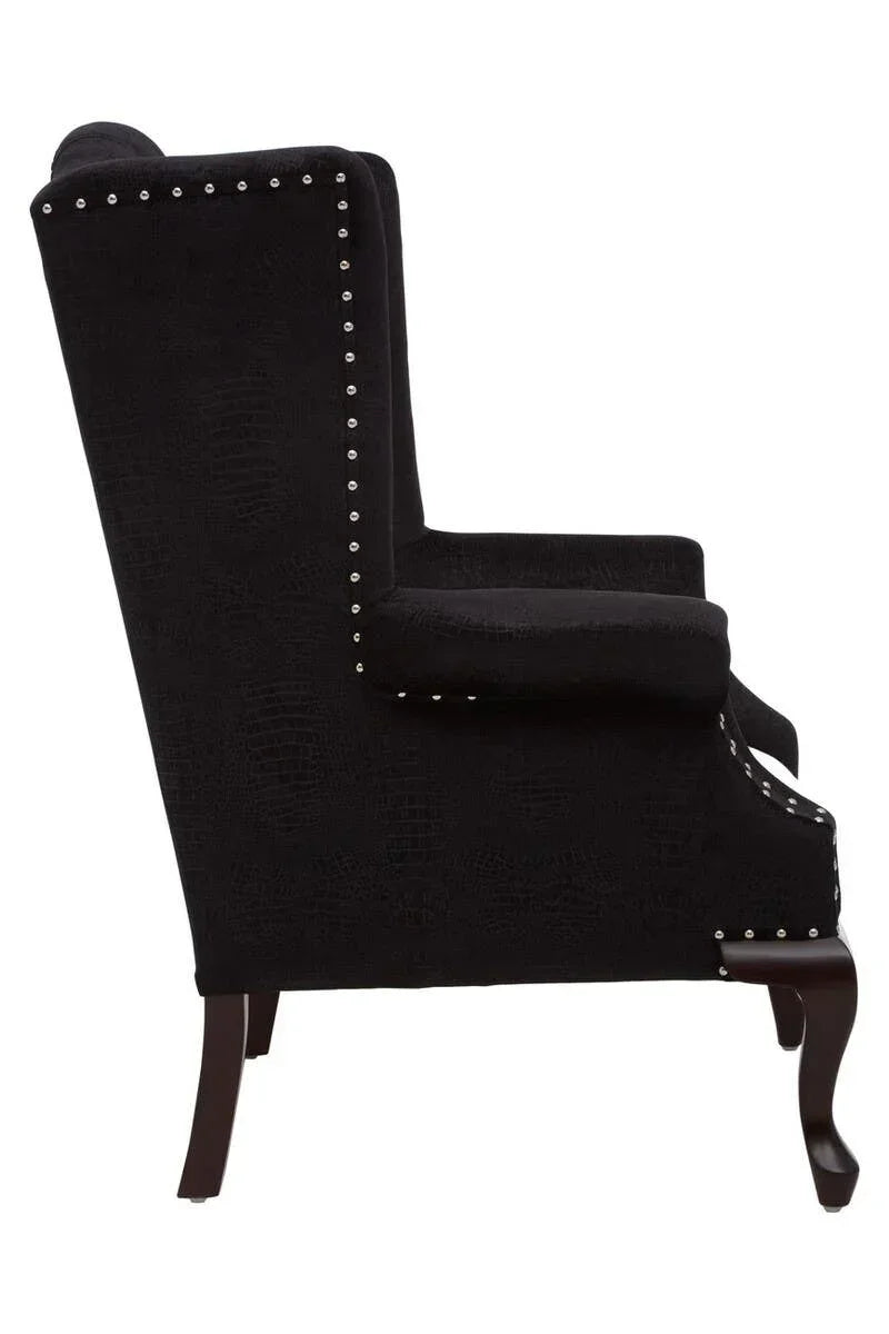 Black fabric armchair with stud detailing and dark wooden legs, side profile view