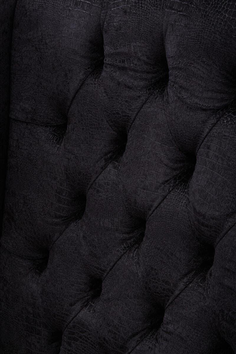 Black textured sofa upholstery with deep button tufting detail