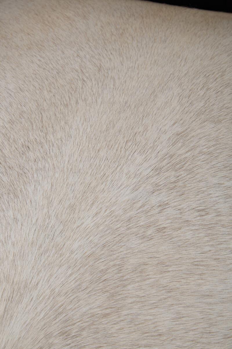 Close-up of beige faux fur upholstery texture on furniture surface