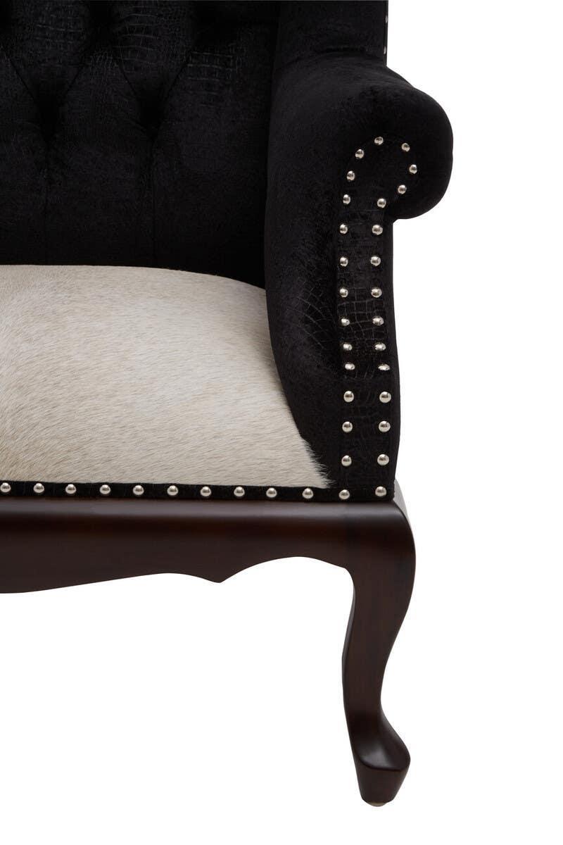 Black fabric armchair with studded trim and wooden leg, cream textured seat detail