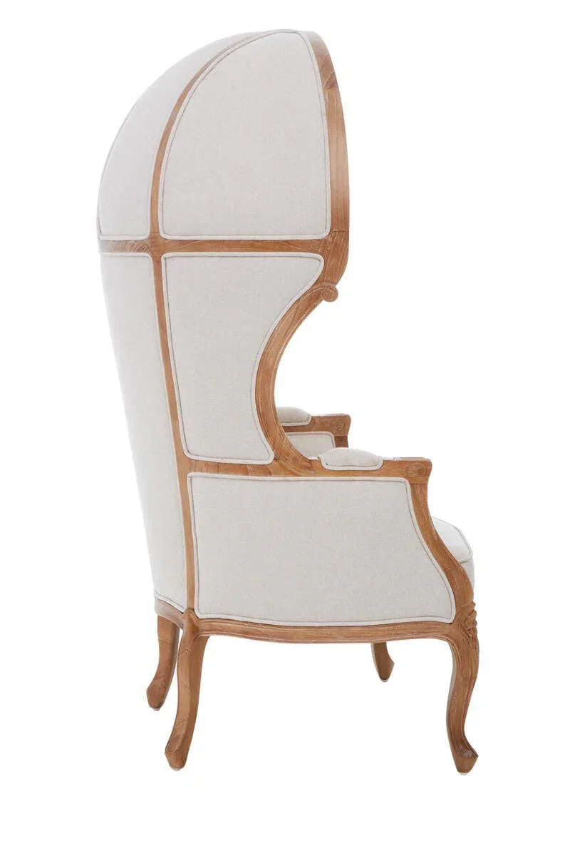 Side view of dome back armchair with light wood frame and cream upholstered panels