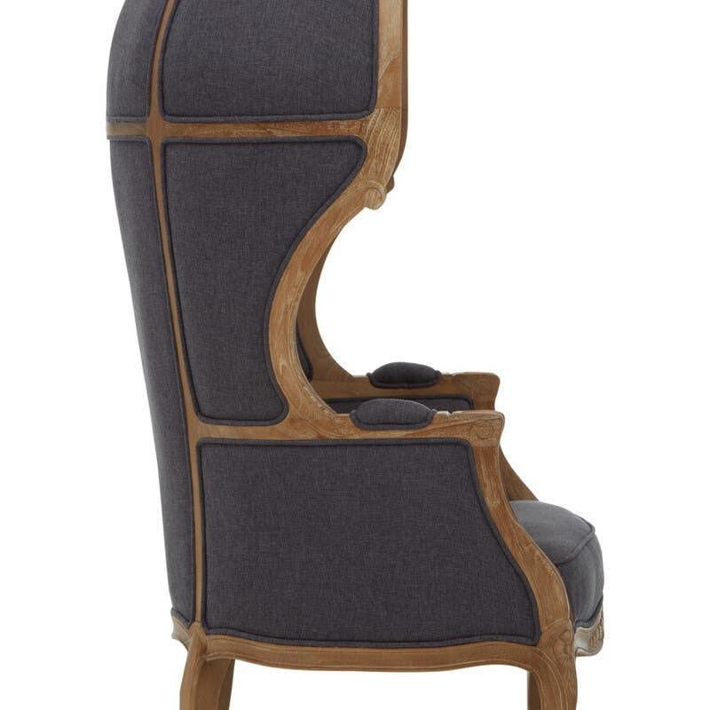 Side view high back armchair with dark fabric upholstery and exposed wood frame