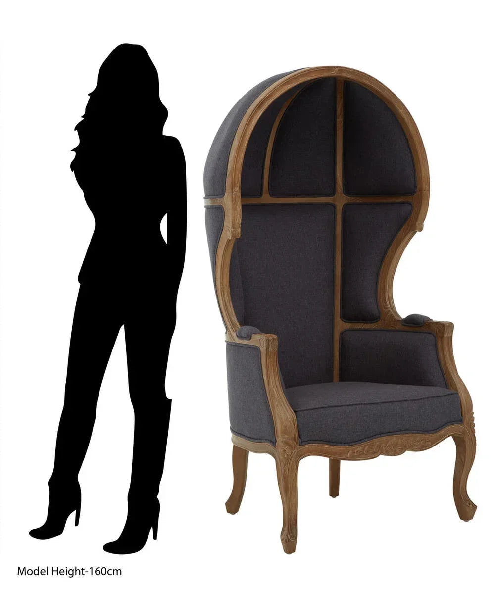 Dark grey canopy accent chair with carved wood frame beside silhouette for scale