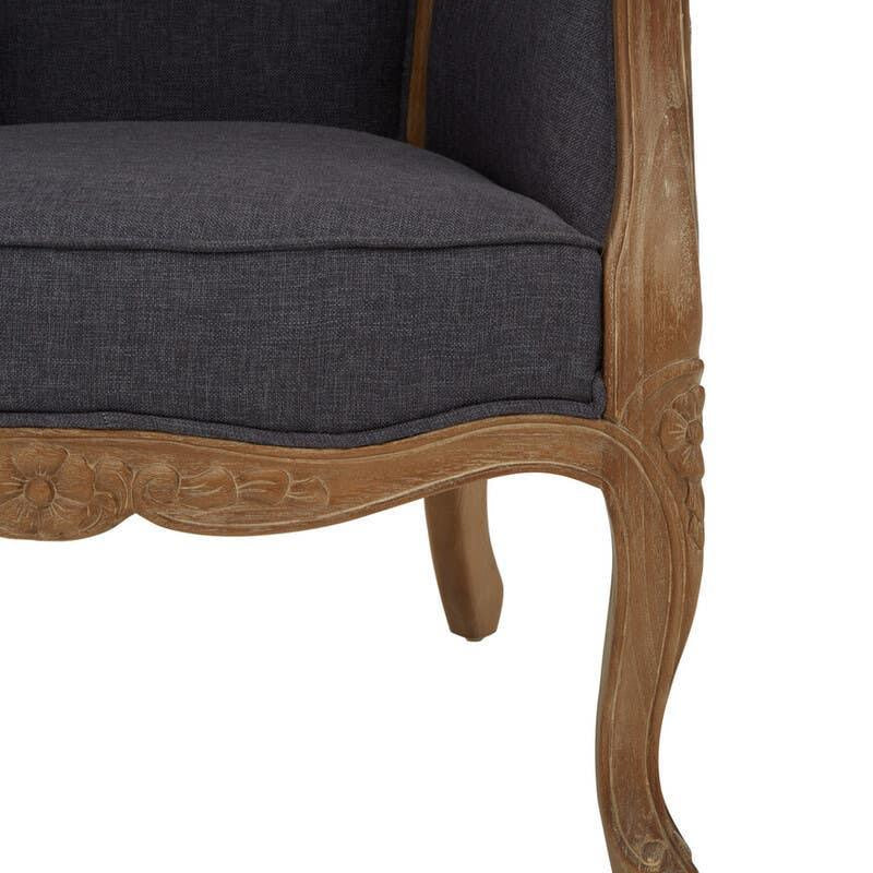 Dark grey upholstered armchair with carved wood frame and floral detail, close-up view