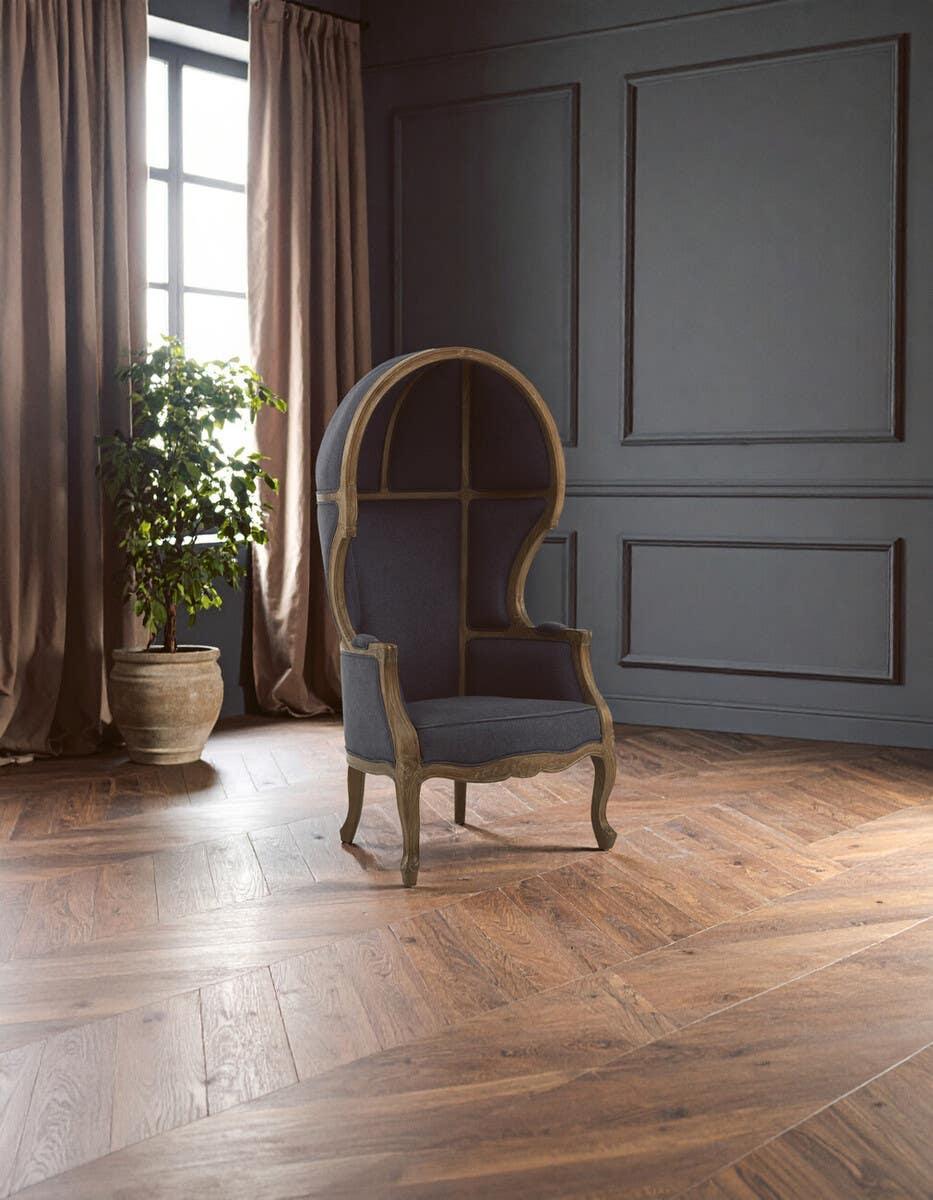 Dark grey upholstered dome canopy armchair with wooden frame in modern living room