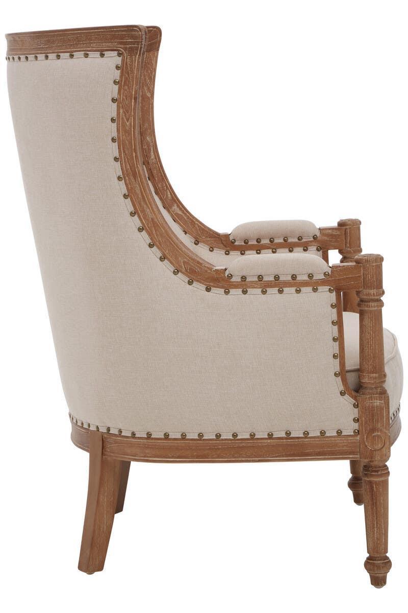 Beige upholstered armchair with wooden frame and decorative stud detailing, side angle view