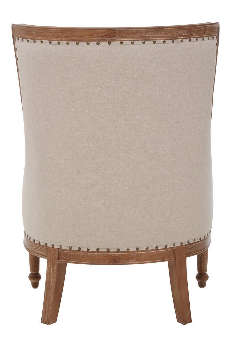 Back view of beige upholstered accent chair with wooden legs and nailhead trim