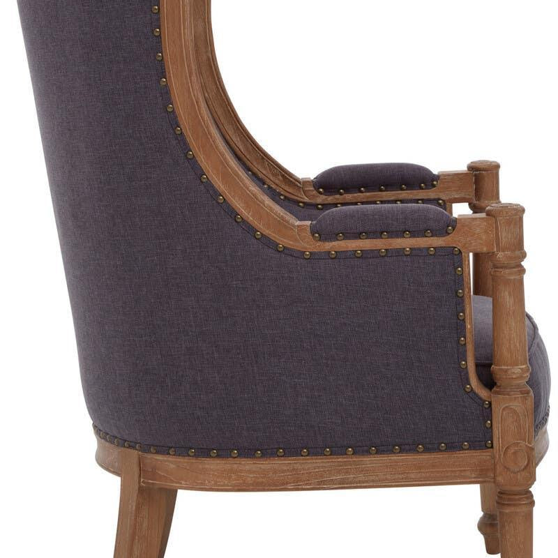 Side view of upholstered armchair with dark fabric and exposed wooden frame with stud detailing