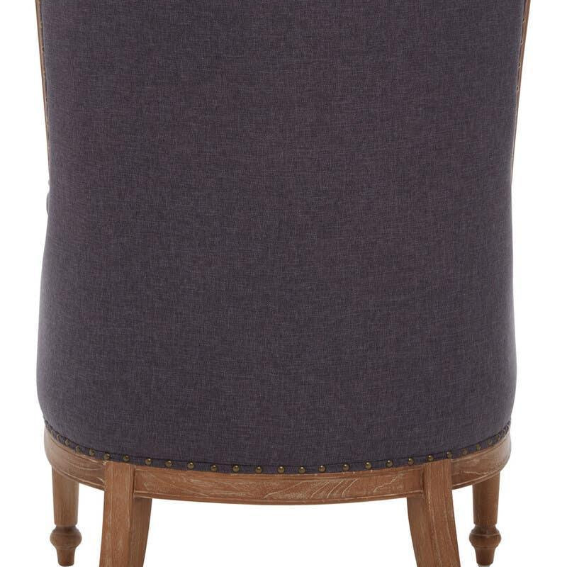Back view of upholstered accent chair with wooden legs and nailhead trim