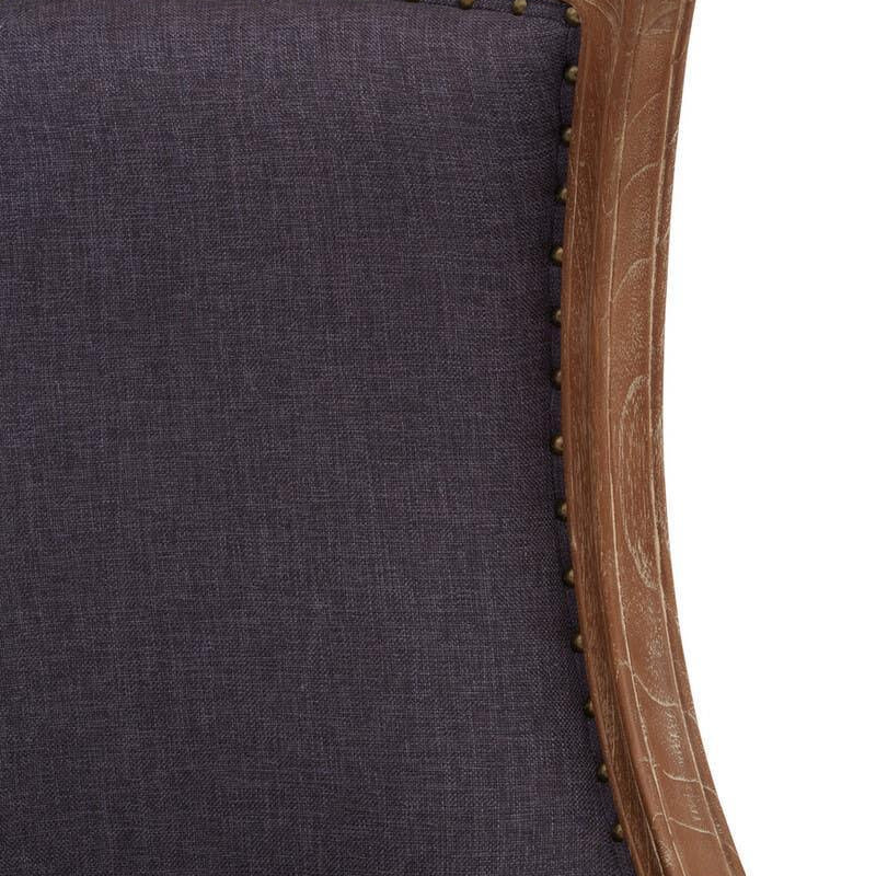 Close-up of dark fabric armchair with wooden frame and antique brass stud detailing