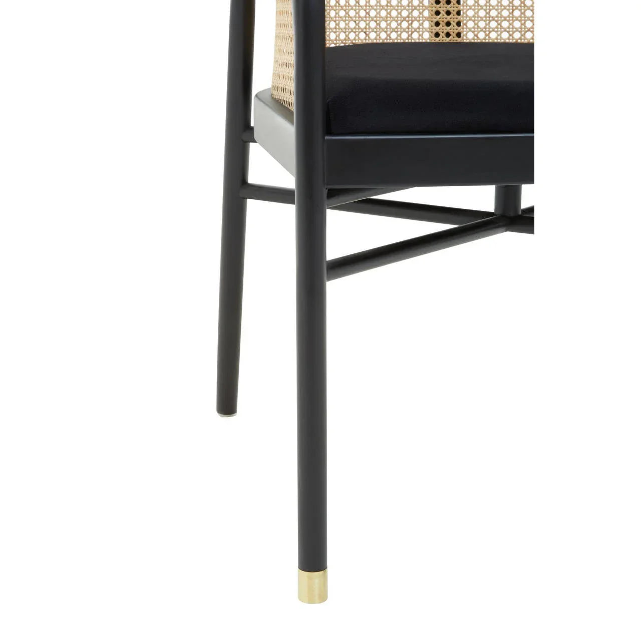 Black dining chair with cane backrest, gold-tipped leg and padded seat, side view