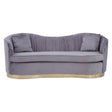 Three-seat sofa upholstered in pleated grey velvet with a curved backrest and two matching cushions. The base features a sleek gold trim, adding an elegant touch to the overall design