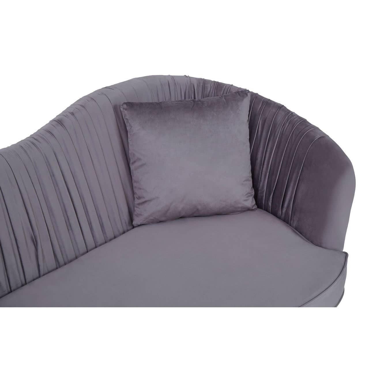 A close-up view of a grey pleated velvet sofa featuring a curved backrest and a single matching cushion. The fabric has a soft, luxurious texture, and the pleats add a stylish detail to the design