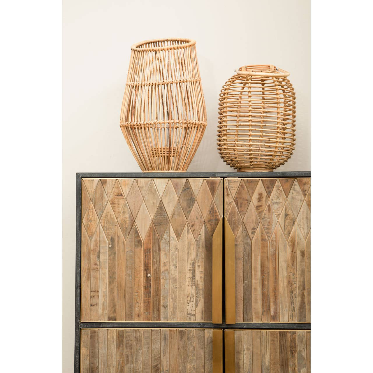Textured wooden cabinet featuring a natural wood finish with a geometric pattern on the doors, complemented by two woven decorative baskets placed on top. The cabinet has a sleek, modern design with a gold handle