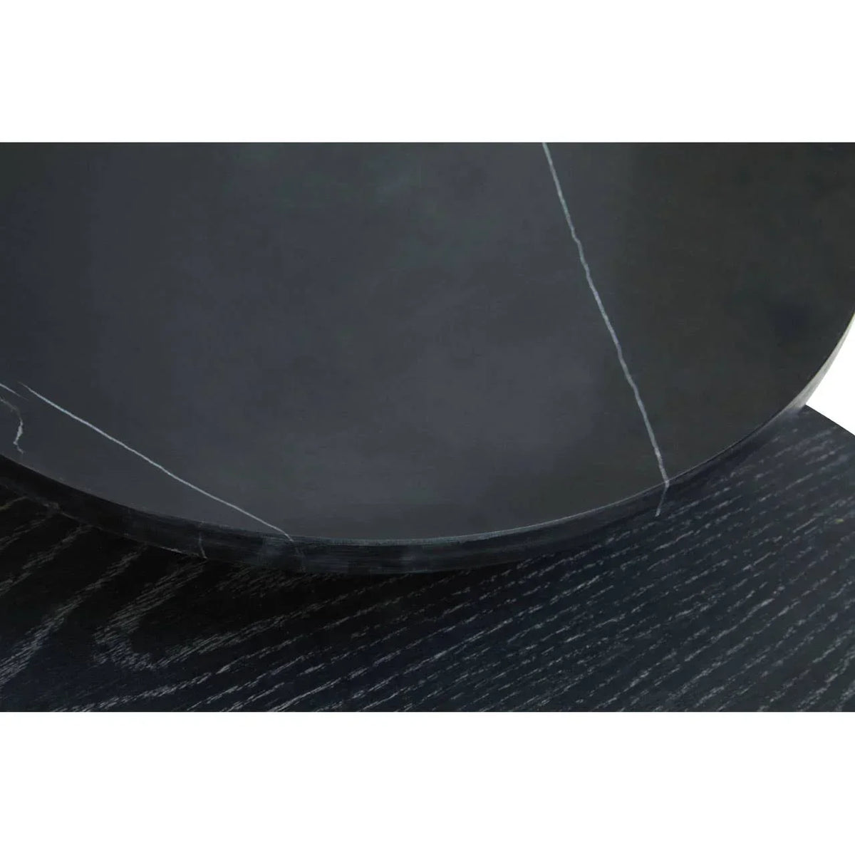 Black marble table top with white veining and dark wood grain base close-up