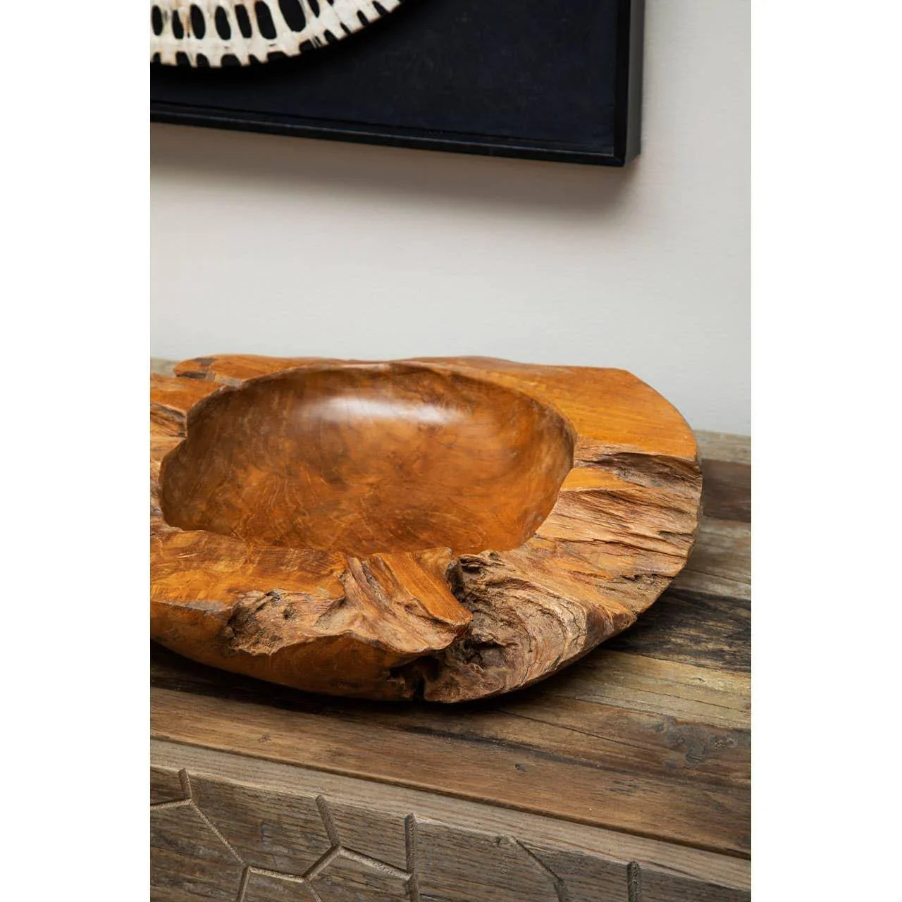 Handcrafted teak wood decorative bowl with natural edge on rustic wooden console table