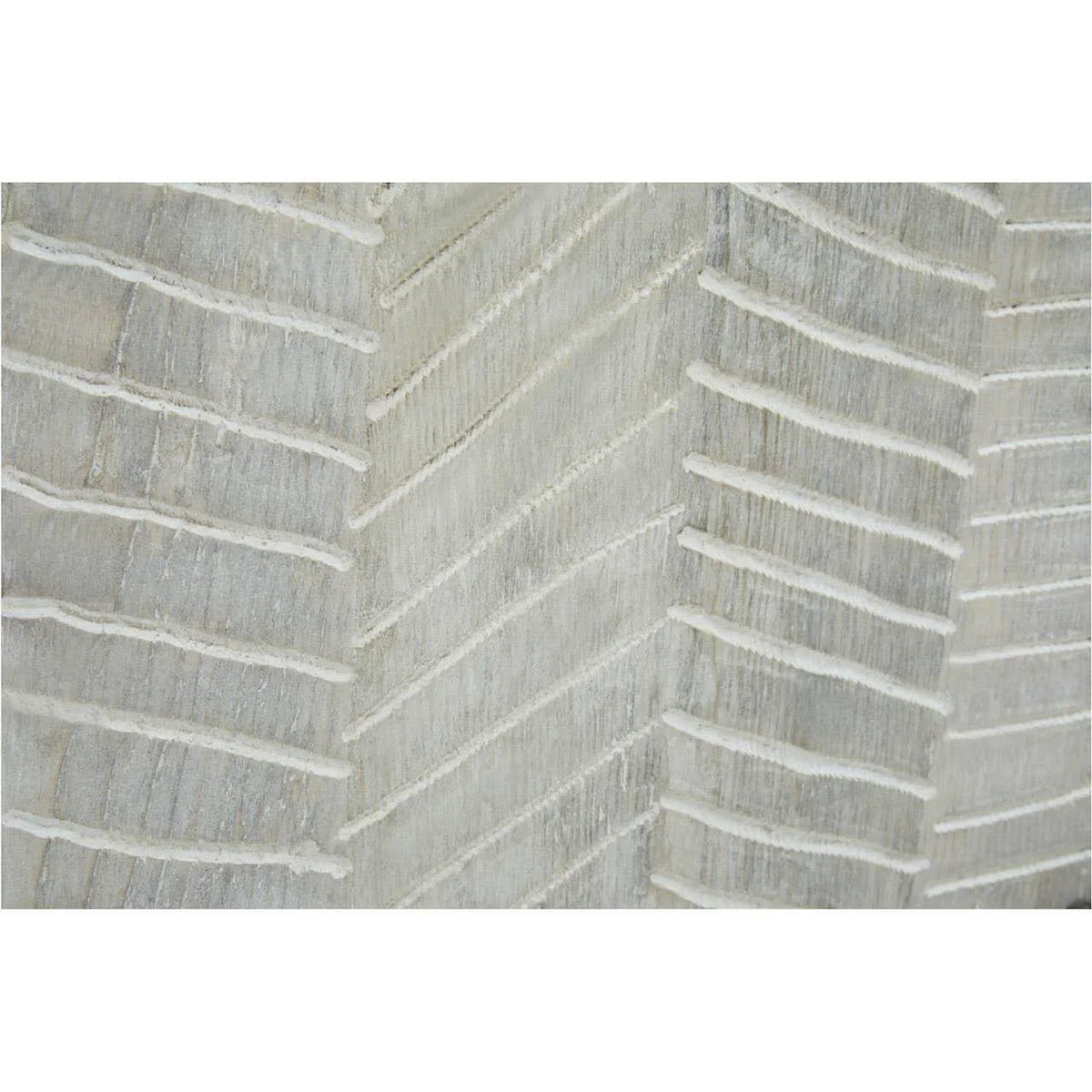Close-up of textured wood furniture panel with white chevron carved pattern