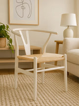 White wooden dining chair with woven seat on cream rug in modern living room