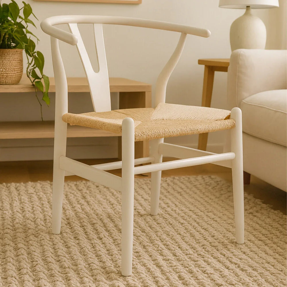 White dining chair with curved back and woven natural seat on beige rug in living room