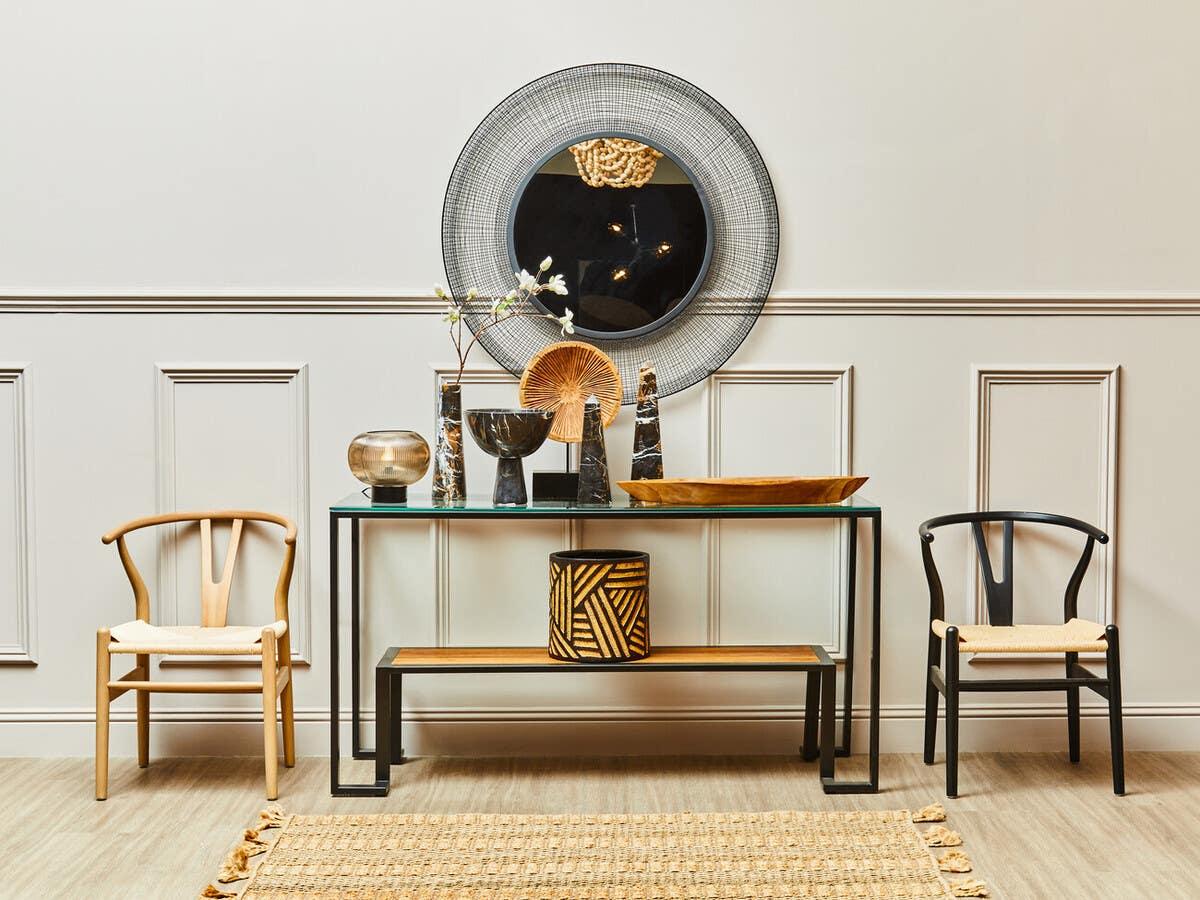 Modern hallway console table with decorative vases, round wall mirror and two accent chairs