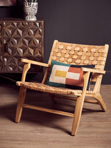 Light wood lounge chair with woven leather seat and geometric cushion in modern living room