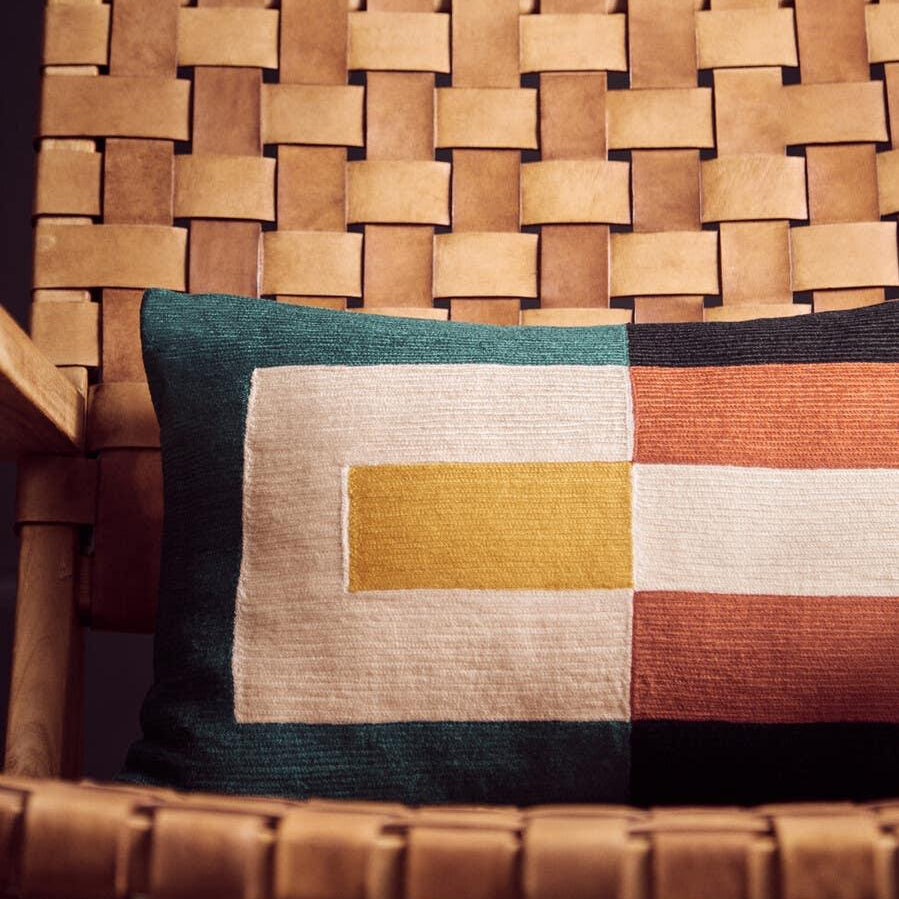 Tan woven leather accent chair with geometric patterned cushion