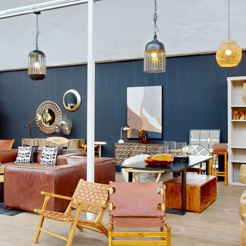 Modern showroom with leather sofas, wooden armchairs, mirrors and accent lighting
