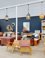 Modern showroom with leather sofas, wooden armchairs, mirrors and accent lighting